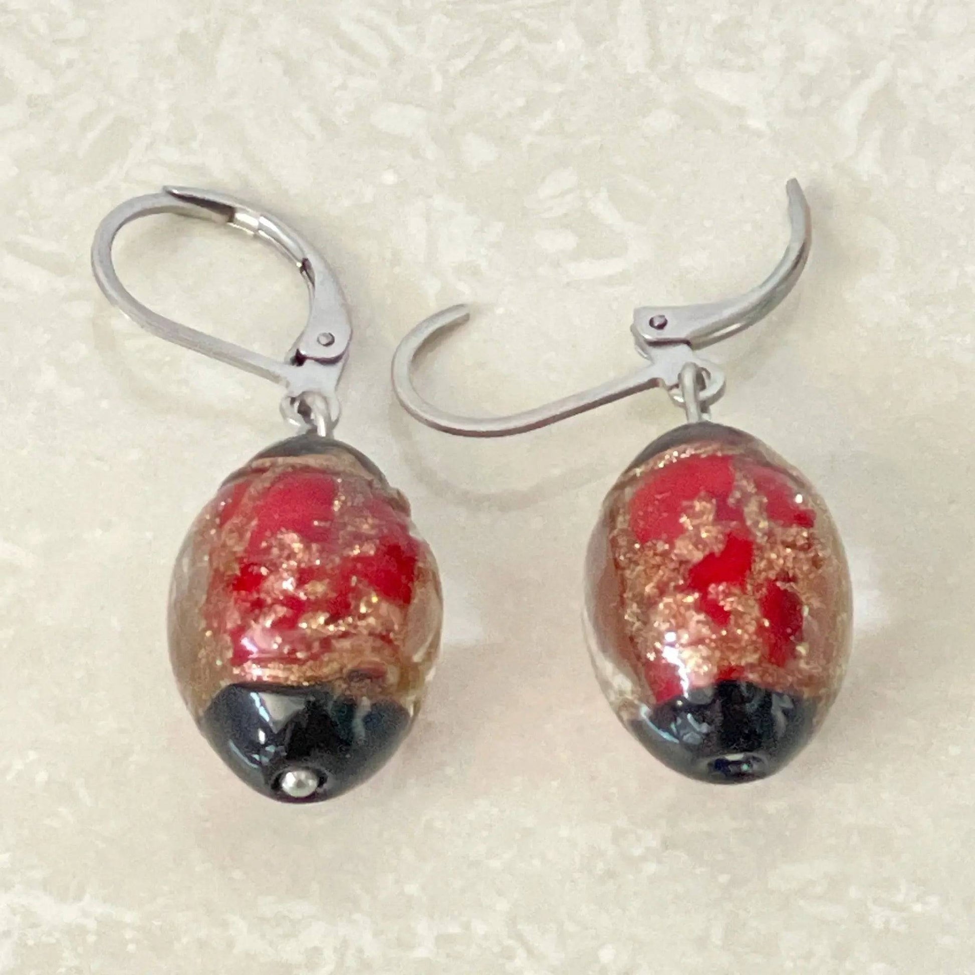 Elegant oval glass earrings showcasing shimmering metallic accents - Uplift Beads